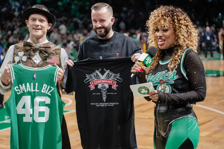 Three people holding jerseys on a basketball court
