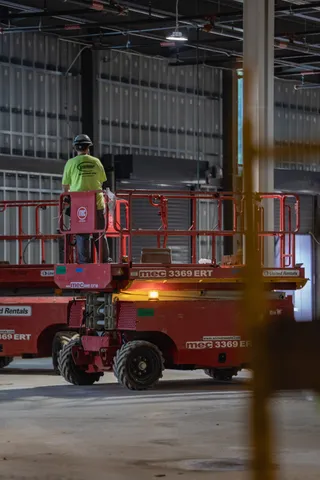 Worker using a scissor lift inside a building