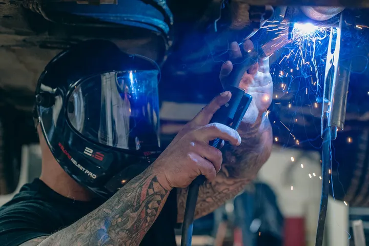 Welder working beneath a vehicle