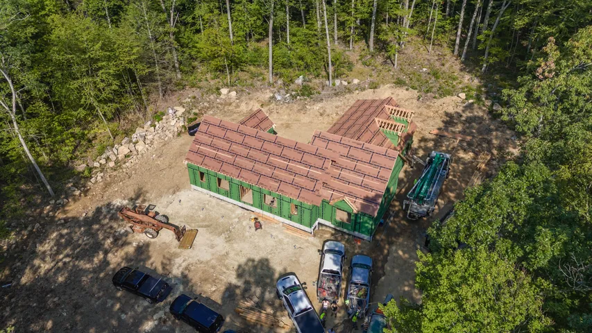 Aerial view of a home being framed in a wooded setting