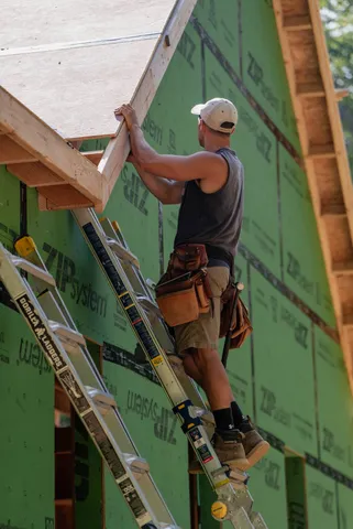 Carpenter working on the exterior of a framed home
